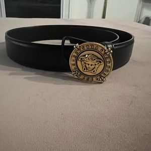 Black leather Versace belt with a gold Medusa buckle.